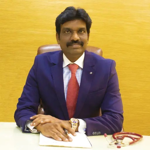 A man with a bald head wearing a blue jacket.