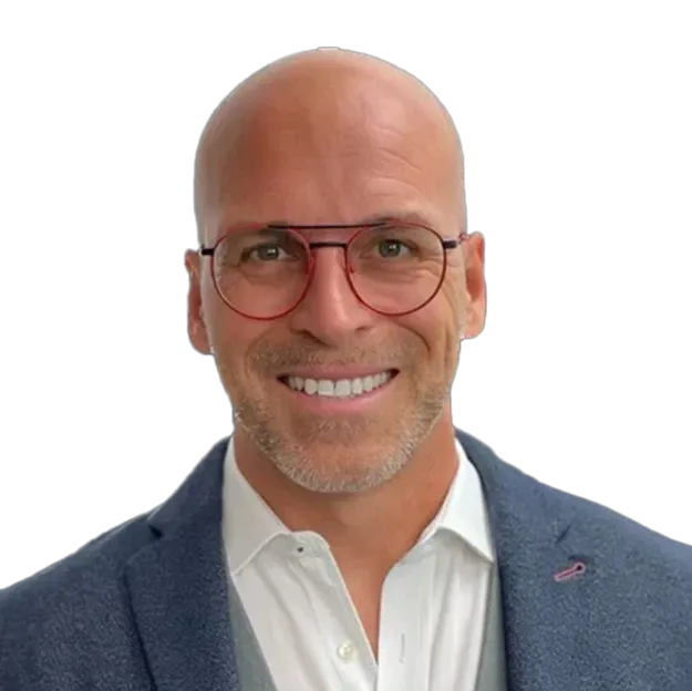 A bald man wearing glasses and a blue jacket.